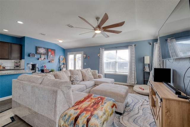 living room featuring light wood-type flooring, ceiling fan, and lofted ceiling