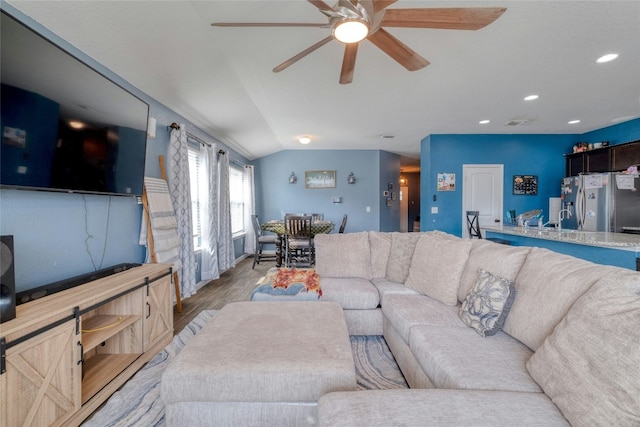 living room featuring ceiling fan, light hardwood / wood-style flooring, and lofted ceiling