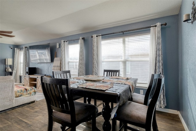 dining room featuring hardwood / wood-style floors, vaulted ceiling, and ceiling fan