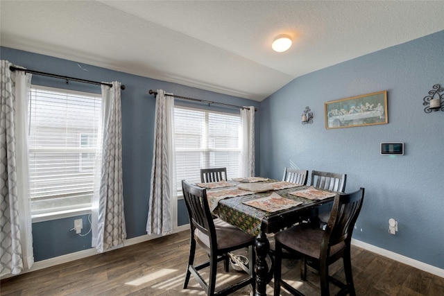 dining space featuring hardwood / wood-style flooring and vaulted ceiling