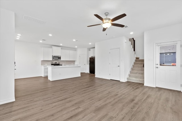 unfurnished living room featuring ceiling fan and light hardwood / wood-style floors