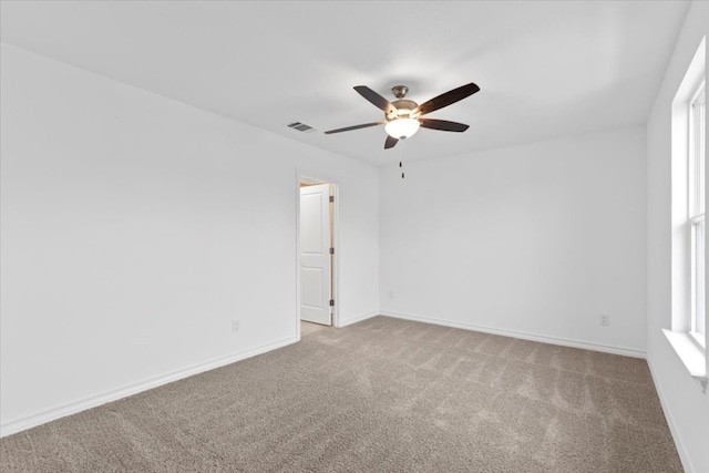 spare room with ceiling fan and light colored carpet