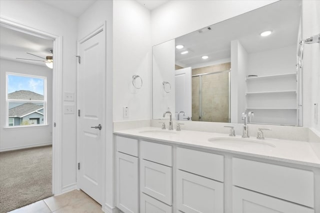 bathroom with tile patterned flooring, vanity, ceiling fan, and walk in shower