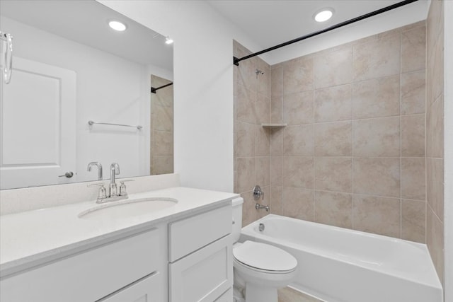 full bathroom featuring tiled shower / bath combo, toilet, and vanity