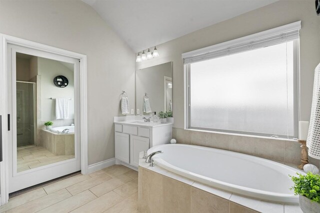 bathroom featuring vanity, lofted ceiling, and shower with separate bathtub