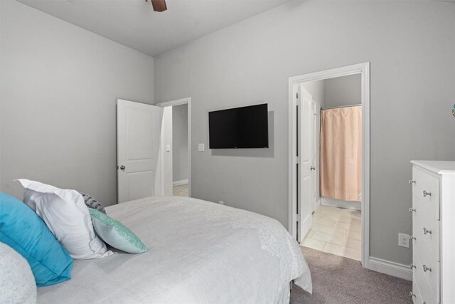 bedroom featuring ensuite bath, ceiling fan, and light carpet