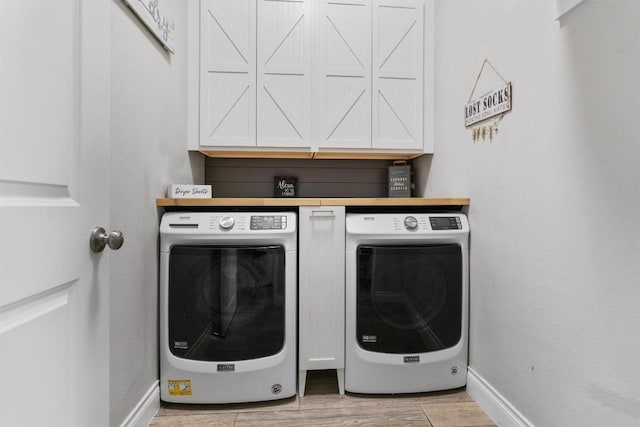 221 Magdalene Way, Liberty Hill, TX 78642 - laundry room featuring cabinets, washer and clothes dryer, and light hardwood / wood-style floors