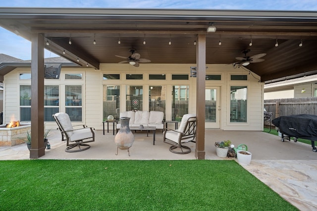 view of patio / terrace featuring ceiling fan and an outdoor living space with a fire pit