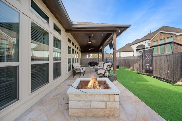 view of patio with ceiling fan and an outdoor fire pit