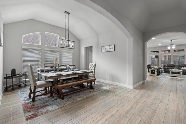 dining space with ceiling fan with notable chandelier and lofted ceiling