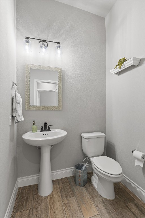 bathroom featuring hardwood / wood-style floors and toilet