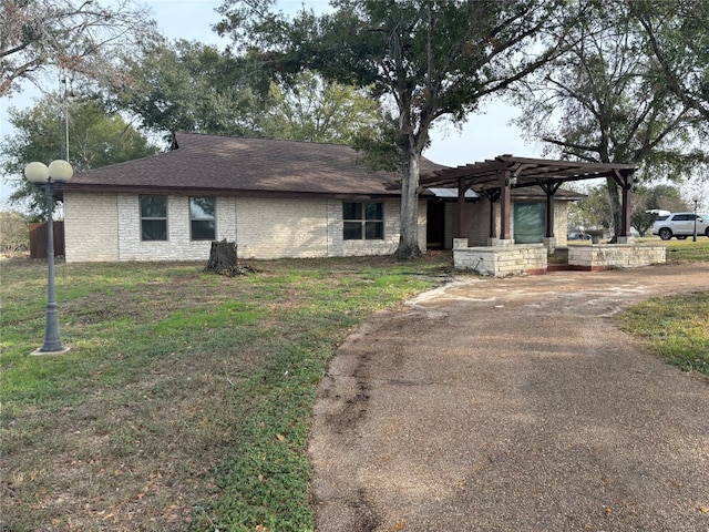 view of front of home with a pergola and a front lawn