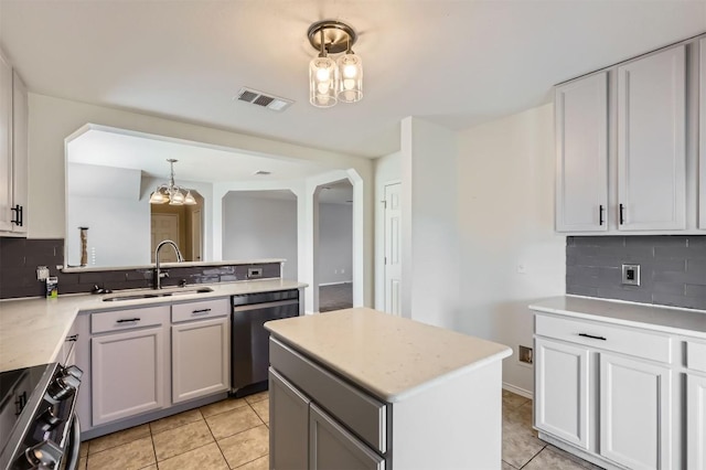 kitchen featuring appliances with stainless steel finishes, tasteful backsplash, sink, light tile patterned floors, and a notable chandelier