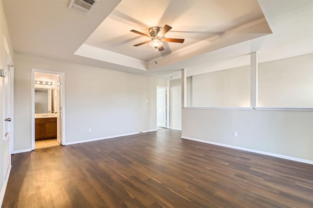 empty room featuring ceiling fan, dark hardwood / wood-style flooring, a raised ceiling, and crown molding