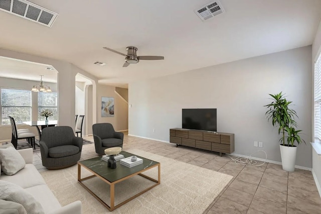 living room with light tile patterned floors and ceiling fan with notable chandelier