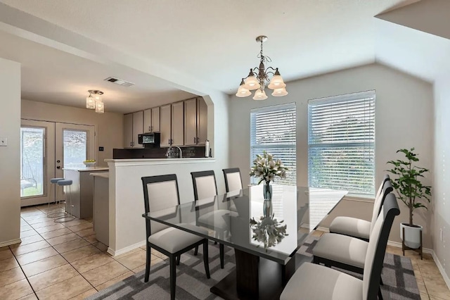 dining room featuring french doors, light tile patterned flooring, and an inviting chandelier