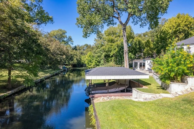 view of dock with a lawn and a water view