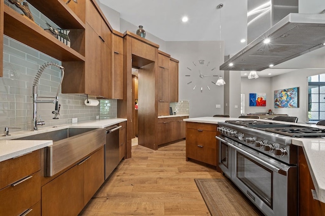 kitchen featuring light hardwood / wood-style flooring, appliances with stainless steel finishes, tasteful backsplash, range hood, and decorative light fixtures