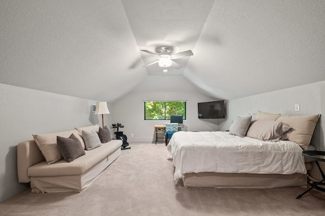 bedroom with a textured ceiling, ceiling fan, light colored carpet, and vaulted ceiling