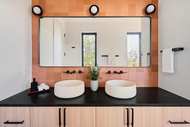 bathroom featuring vanity and tasteful backsplash