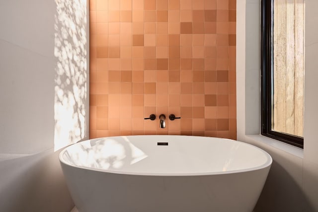 bathroom with tile walls and a bathing tub