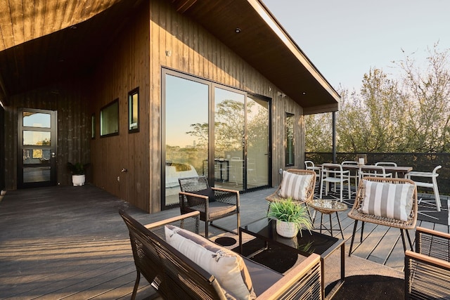 deck at dusk featuring outdoor lounge area and a water view