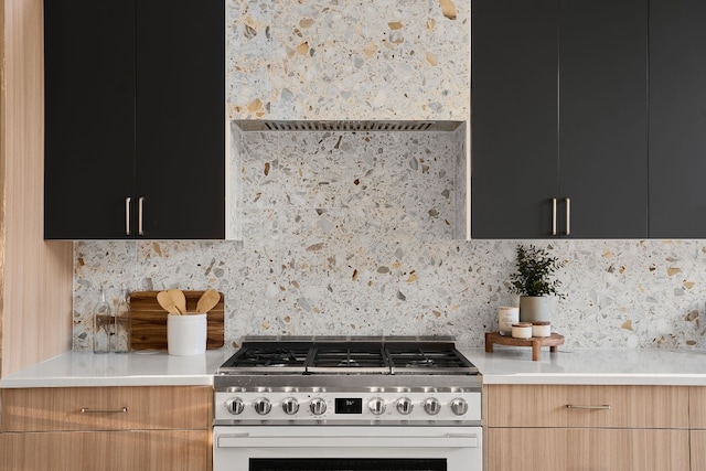 kitchen featuring decorative backsplash and high end stove