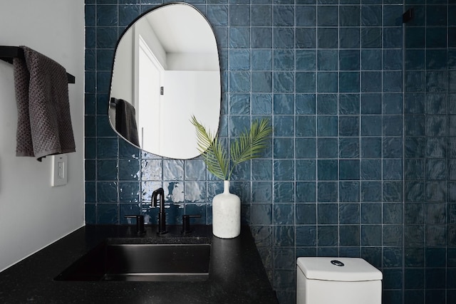 bathroom featuring decorative backsplash, toilet, sink, and tile walls