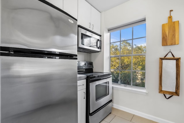 kitchen featuring white cabinets, light tile patterned floors, and appliances with stainless steel finishes