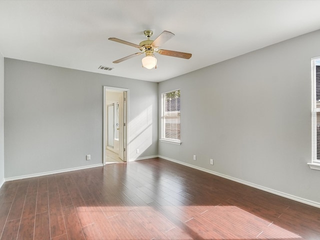 empty room with ceiling fan and dark hardwood / wood-style flooring