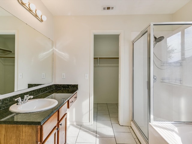 bathroom featuring vanity, tile patterned floors, and walk in shower