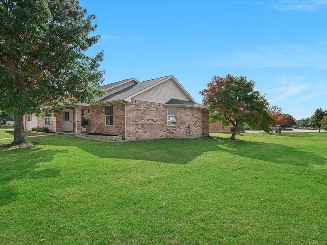 view of side of home with a lawn