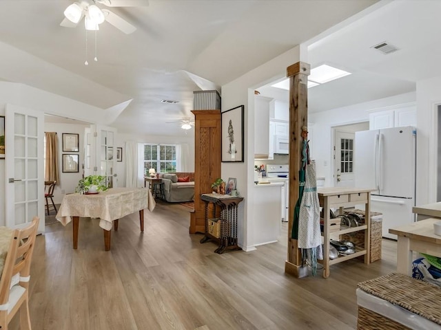 dining room featuring light hardwood / wood-style floors, ceiling fan, and vaulted ceiling