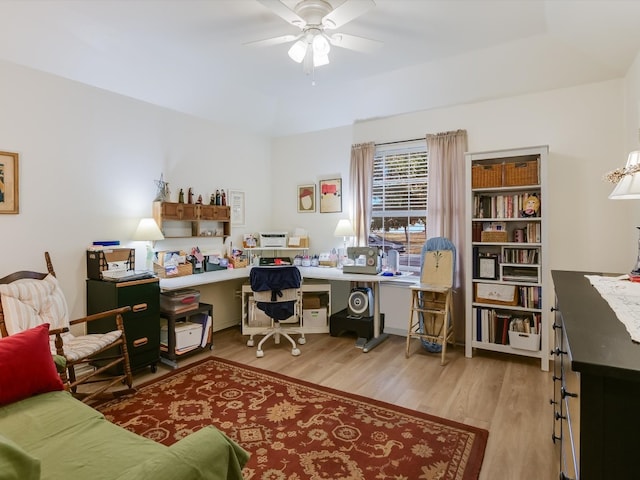 office with light wood-type flooring and ceiling fan