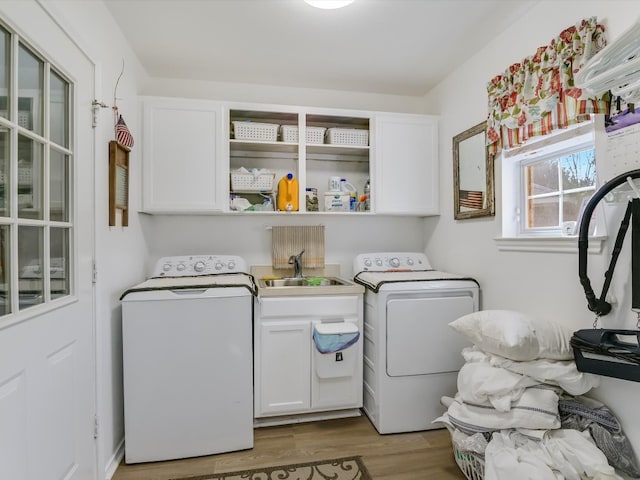 laundry room featuring sink, washer and clothes dryer, cabinets, and wood-type flooring