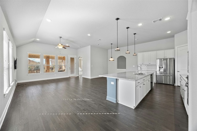 kitchen featuring stainless steel refrigerator with ice dispenser, a center island with sink, white cabinetry, and dark wood-type flooring