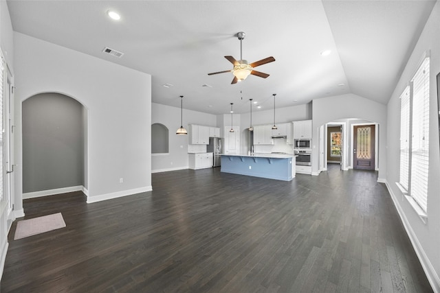 unfurnished living room featuring dark hardwood / wood-style floors, a wealth of natural light, lofted ceiling, and ceiling fan