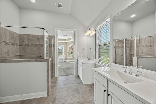 bathroom featuring vanity, a shower with shower door, a wealth of natural light, and vaulted ceiling