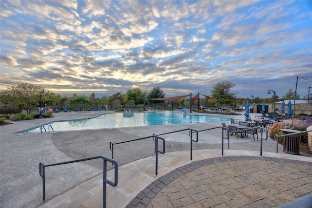 pool at dusk with a patio