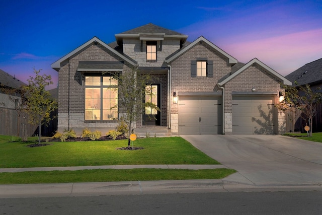 view of front of house with a garage, fence, brick siding, concrete driveway, and a lawn