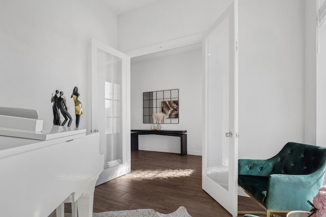 corridor with baseboards and wood finished floors