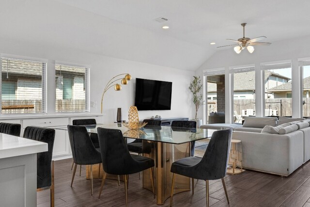 dining area featuring visible vents, a ceiling fan, dark wood finished floors, and vaulted ceiling