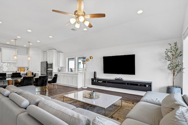 living room with vaulted ceiling, ceiling fan, and dark wood-type flooring