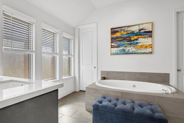 bathroom featuring tile patterned floors, lofted ceiling, and a garden tub