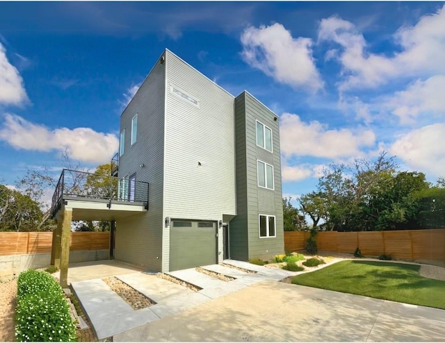 view of side of property featuring a lawn, a garage, and a balcony