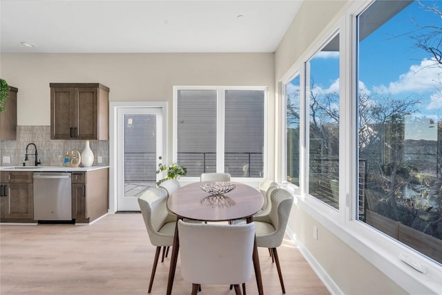 dining area featuring light wood-type flooring and sink