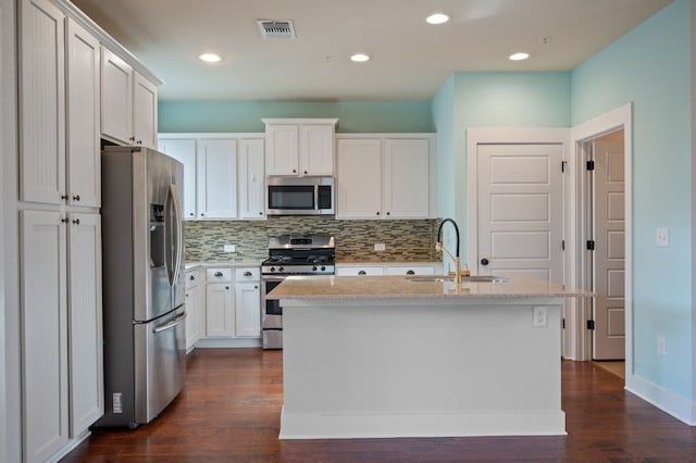 kitchen with white cabinets, sink, stainless steel appliances, and a kitchen island with sink