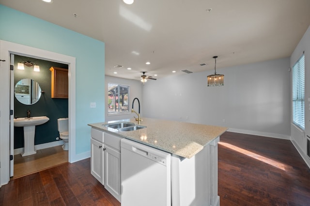 kitchen featuring white dishwasher, a center island with sink, sink, dark hardwood / wood-style floors, and white cabinetry