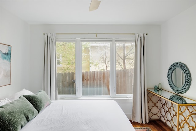 bedroom featuring multiple windows, wood-type flooring, and ceiling fan