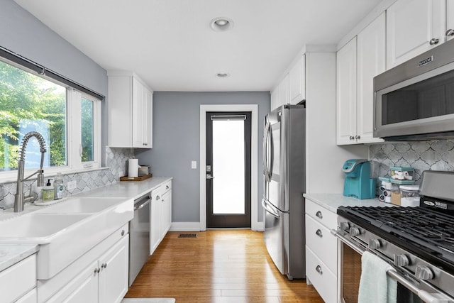 7611 Providence Ave Unit A, Austin, TX 78752 - kitchen featuring appliances with stainless steel finishes, white cabinets, light countertops, and recessed lighting